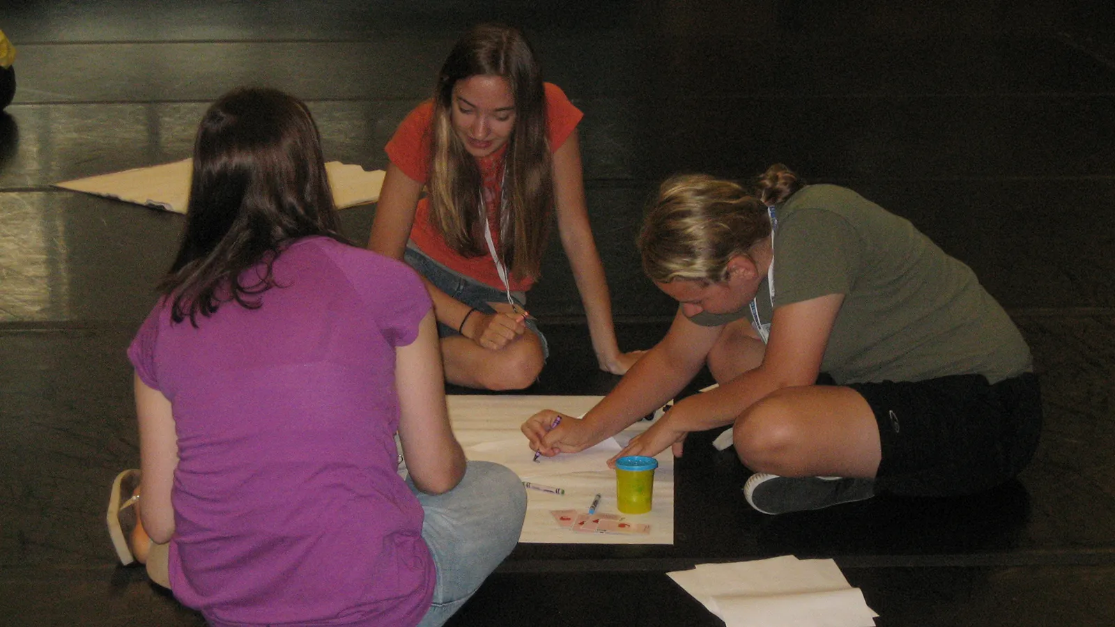 Three students working with art materials
