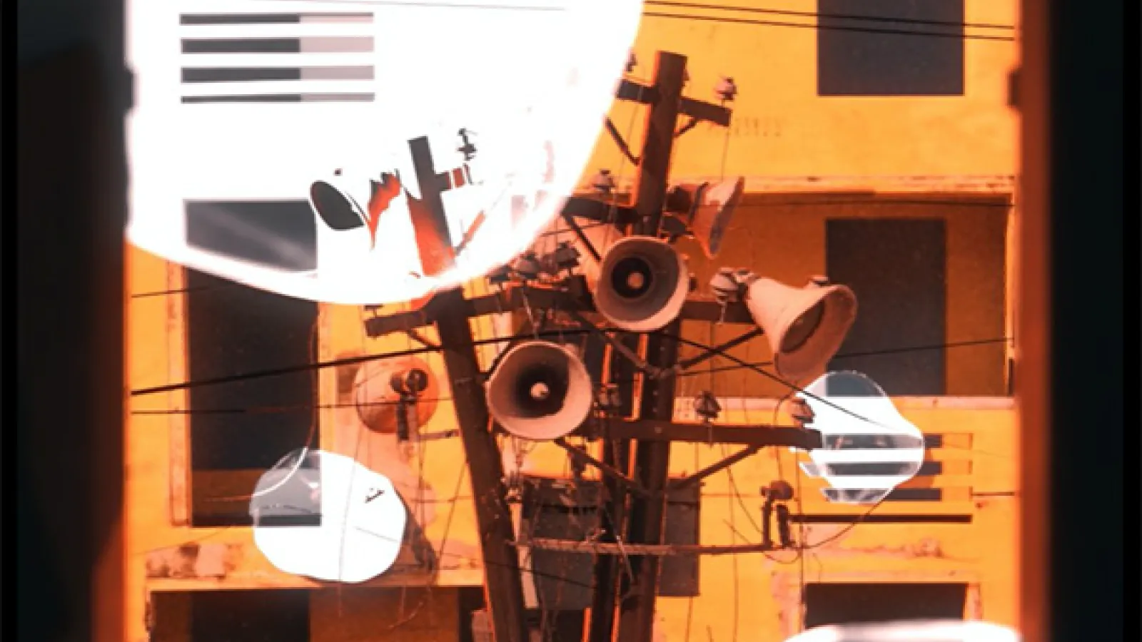 still from film, loud speakers on utility poles
