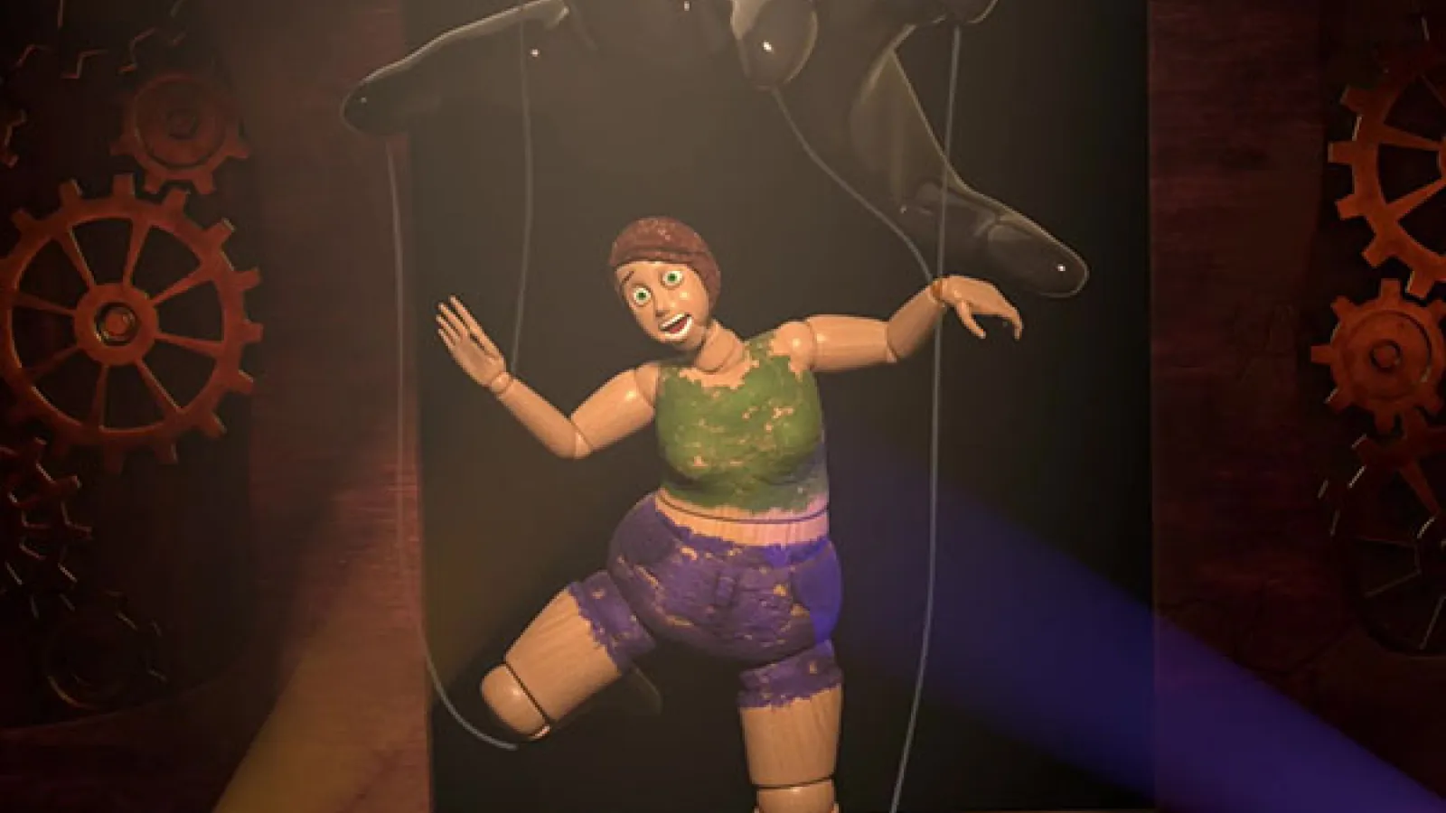 A still shot from the Self in Progress animation, a marionette being operated from a hand above