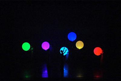 Dancers interact with illuminated inflatable balls