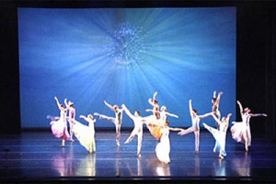 Dancers in front of large screen with digital projection