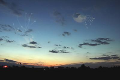 Still from The Approach showing a twighlight landscape with puffy clouds and jelly fish in the sky