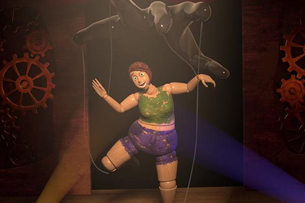 A still shot from the Self in Progress animation, a marionette being operated from a hand above