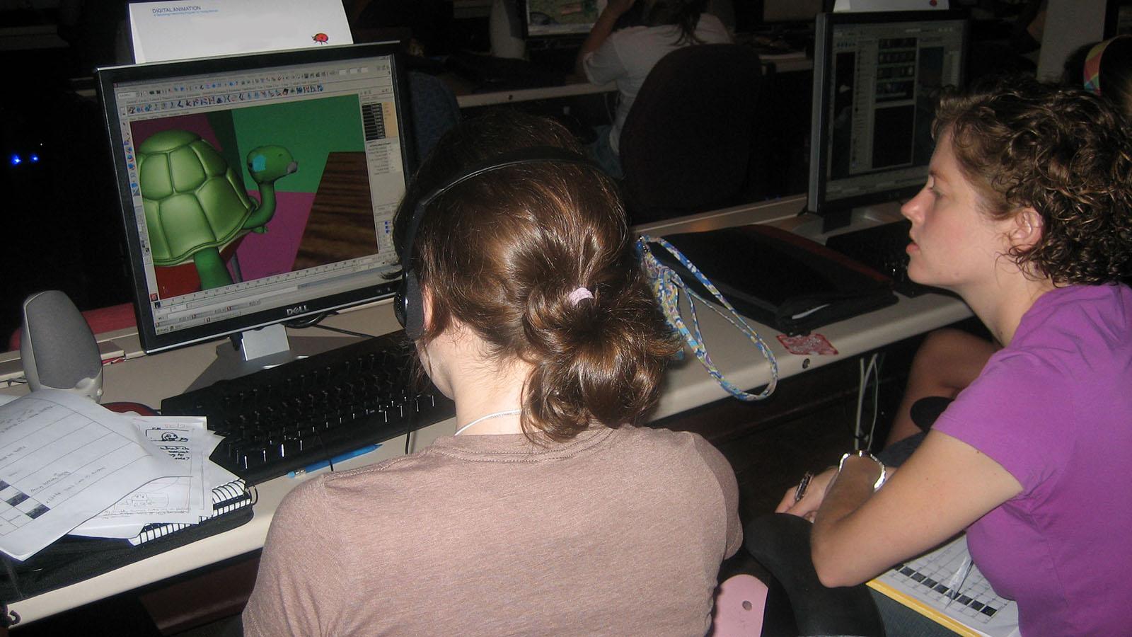 a student and mentor at a computer working on an animation