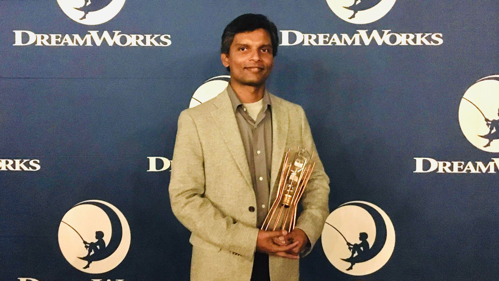 A photo of Lakshika Udakandage holding his Ingenuity Award from DreamWorks